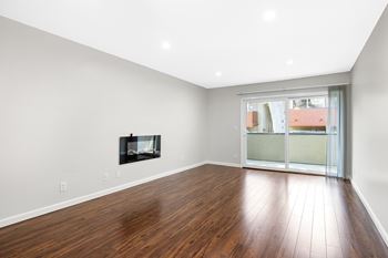 A room with a fireplace and wooden flooring.